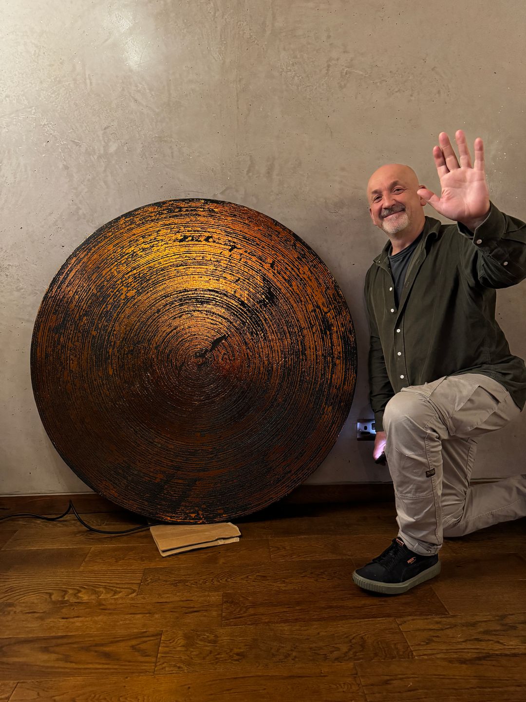 Josef beside a bronze circle panel he finished by hand