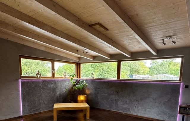 Finished charcoal plaster wall beneath timber beams