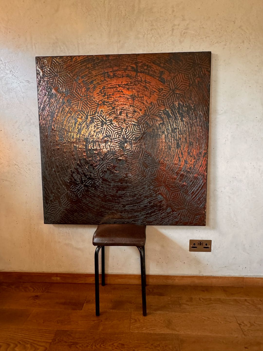 Carved metallic GLO Module on a pale wall