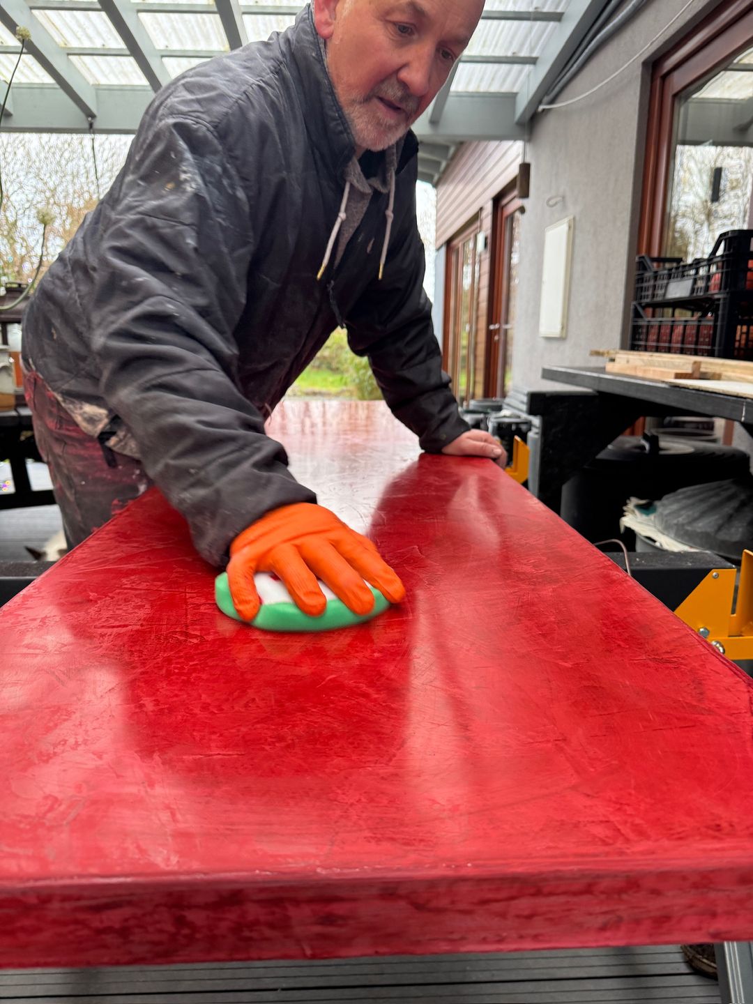 Josef hand-finishing a red panel